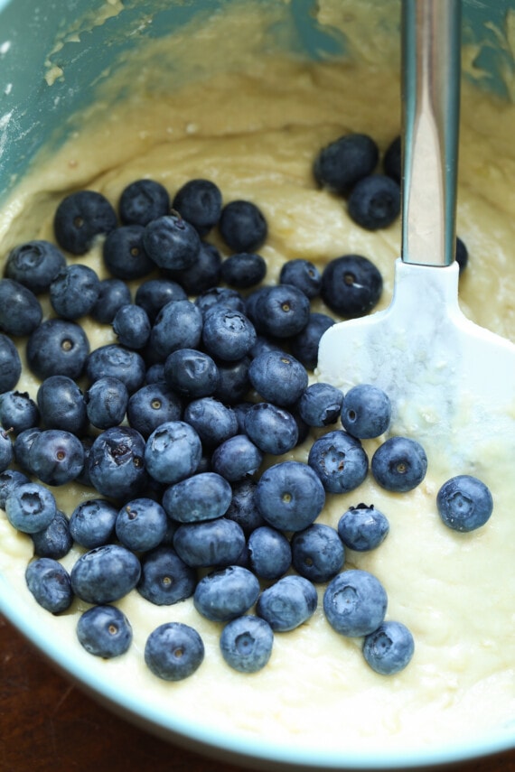 Arándanos frescos mezclados con masa para muffins de plátano.
