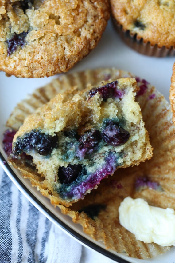 La mitad de un muffin con arándanos frescos.