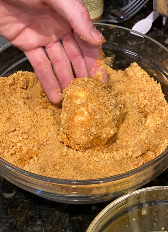 Una bola de helado envuelta en copos de maíz triturados y galletas de vainilla.