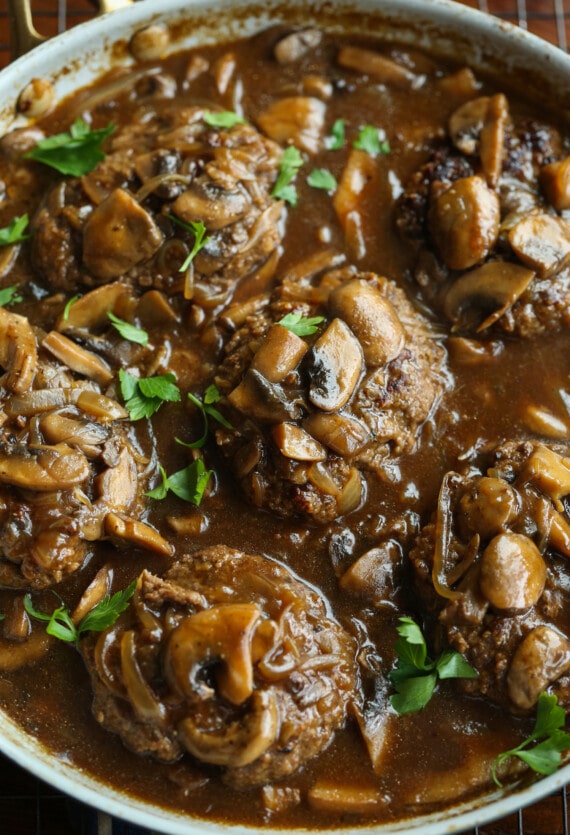 Filete Salisbury con salsa y aderezado con perejil en una sartén