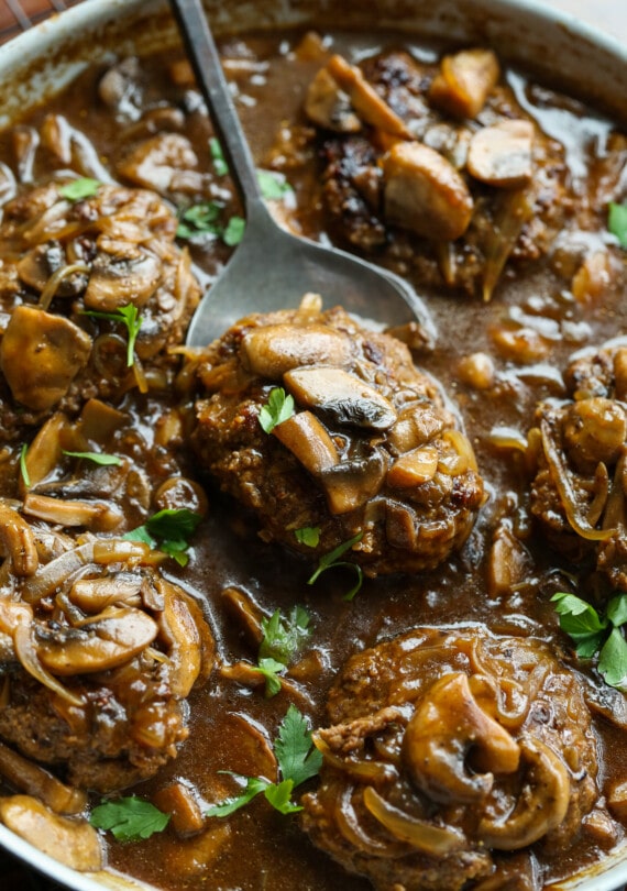 bistec de carne molida cocido en una sartén con salsa marrón