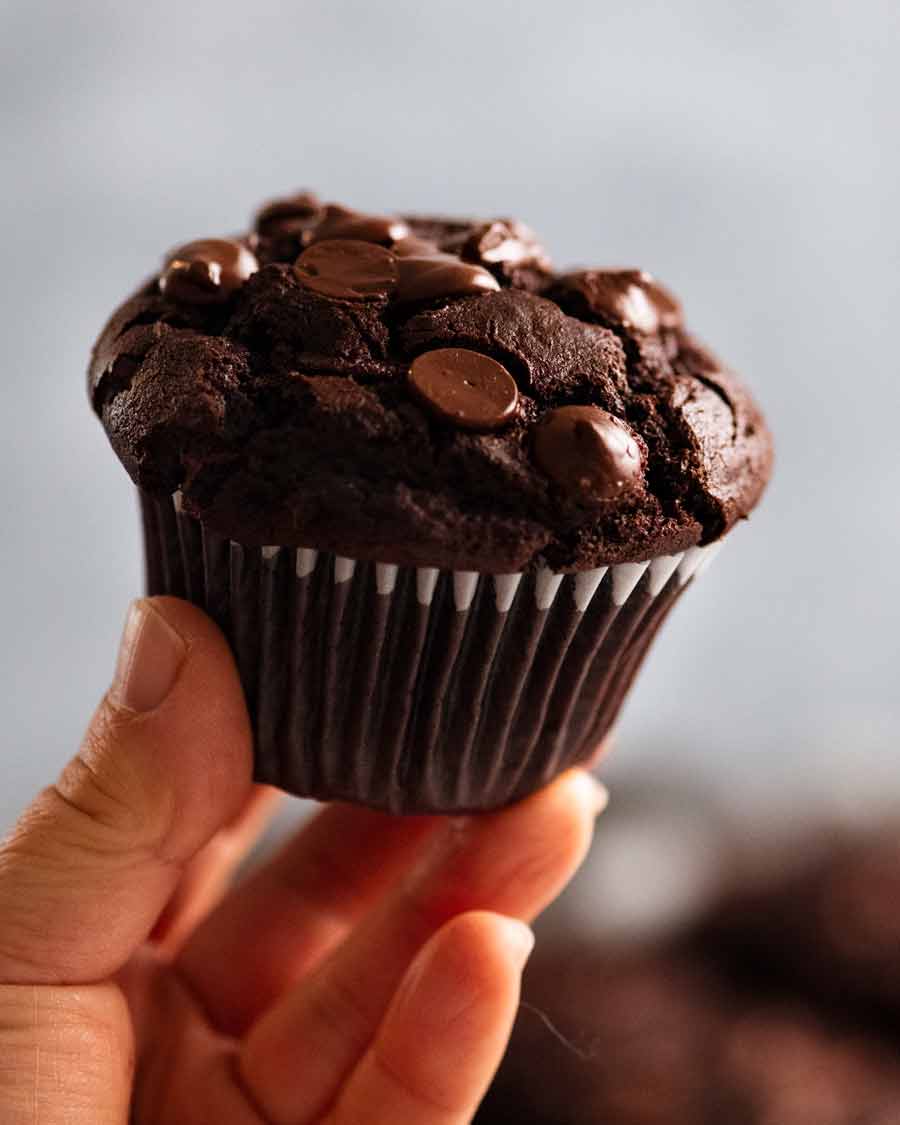 Mano sujetando muffin de chocolate