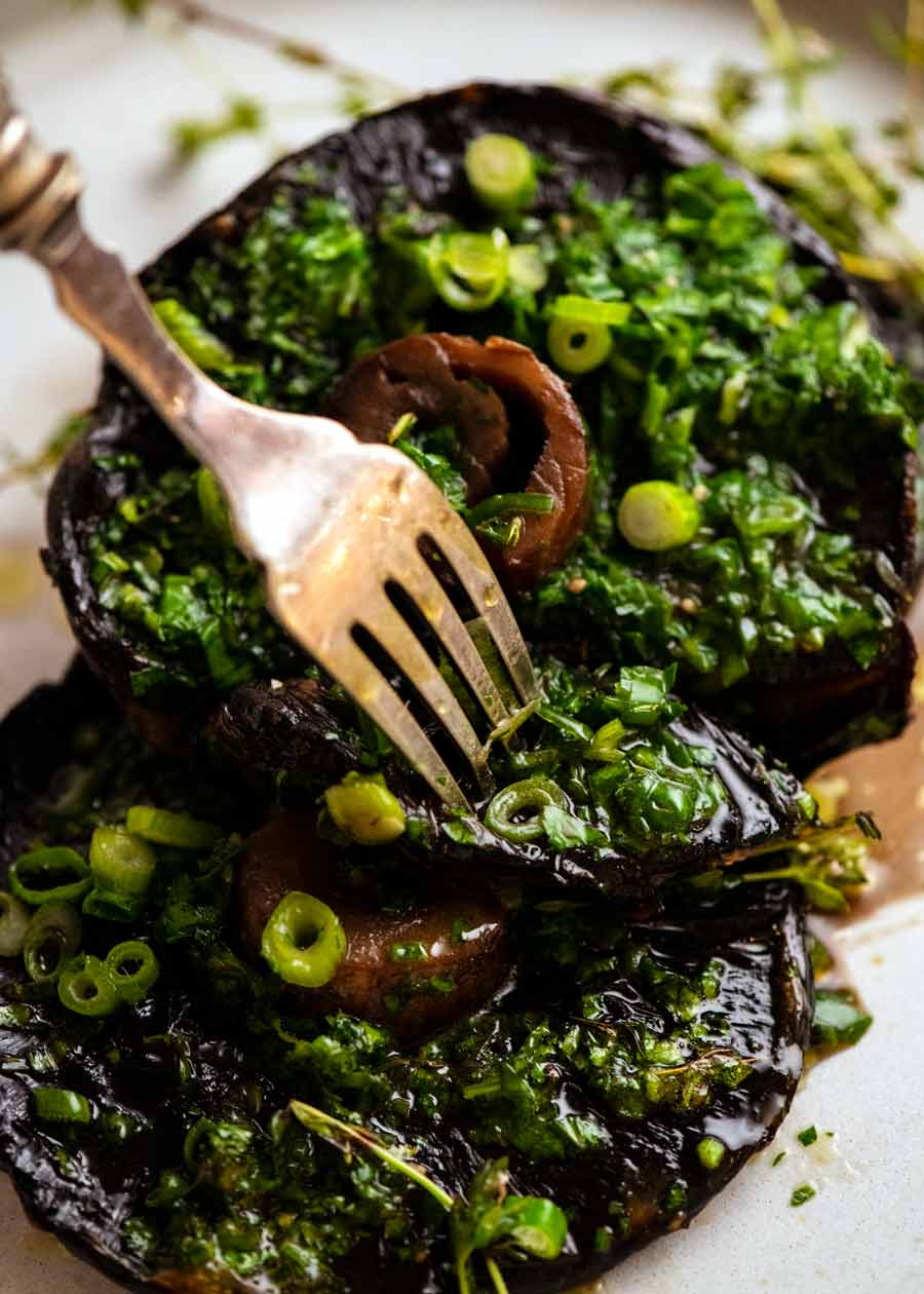 Tenedor para recoger champiñones grandes asados ​​con mantequilla de tomillo y cebolla verde