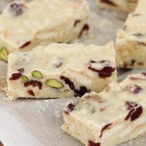 Trozos de rodaja de chocolate blanco con pistachos y arándanos.