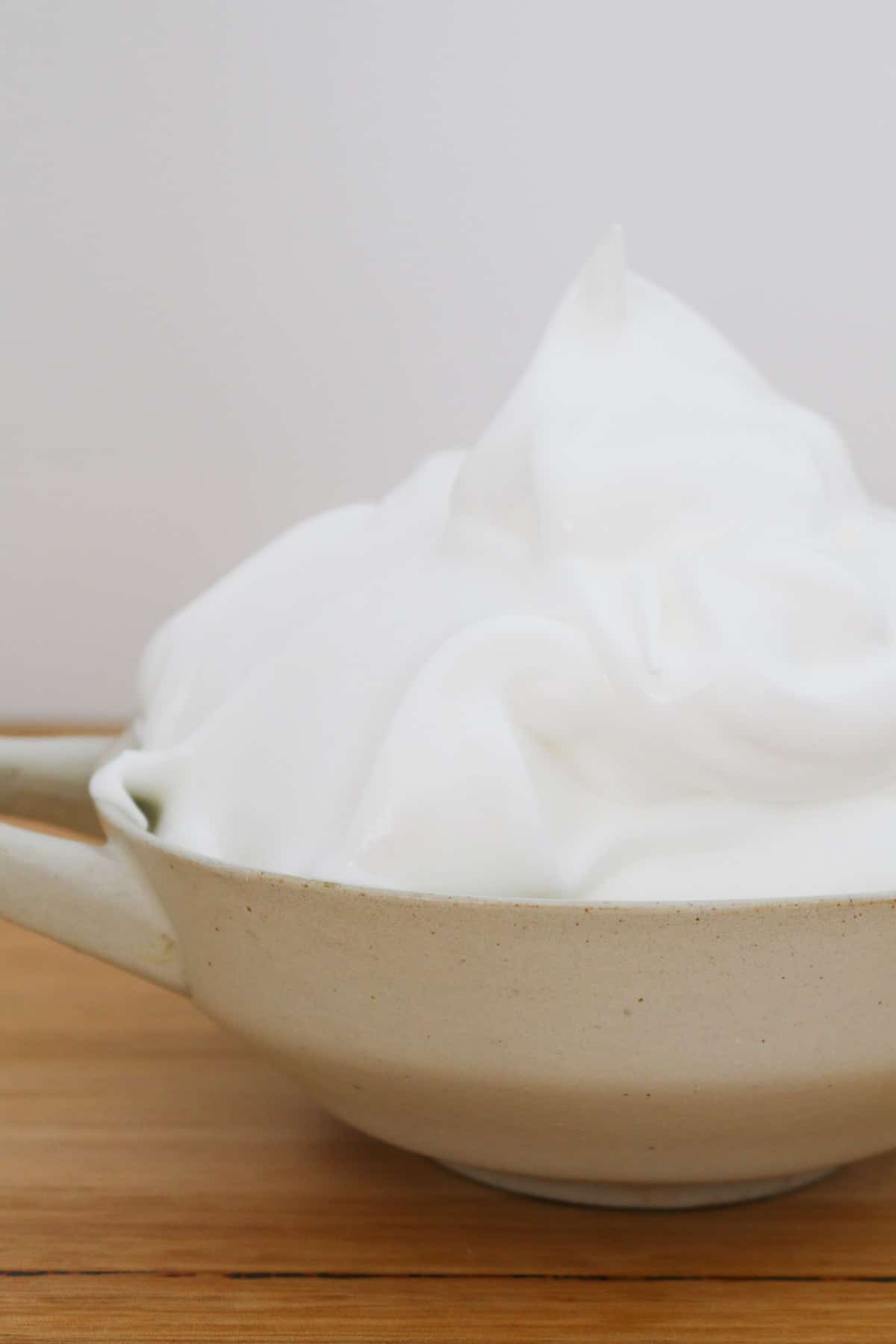 Un cuenco gris con merengue blanco.