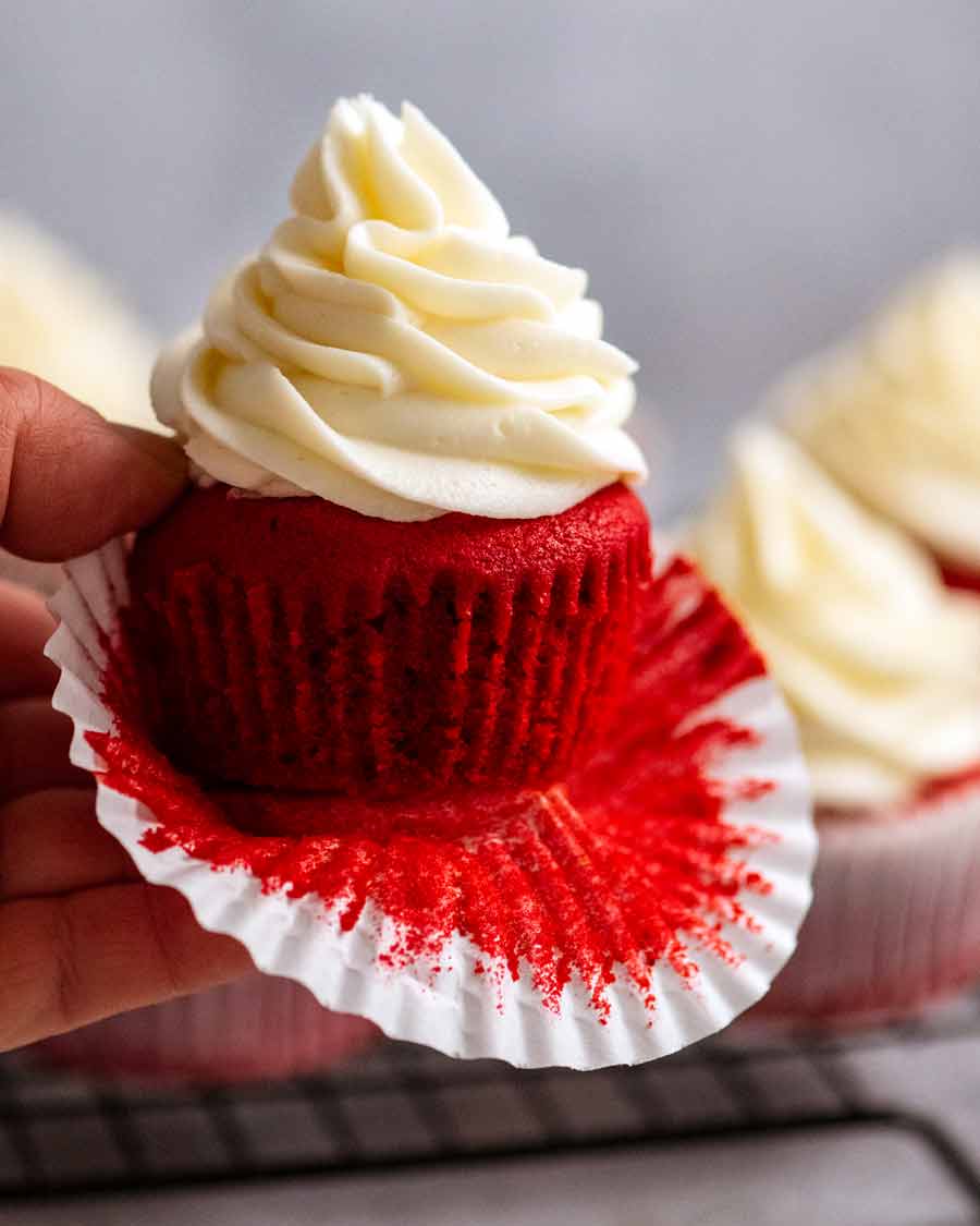 Cerca de un cupcake de terciopelo rojo con glaseado de queso crema
