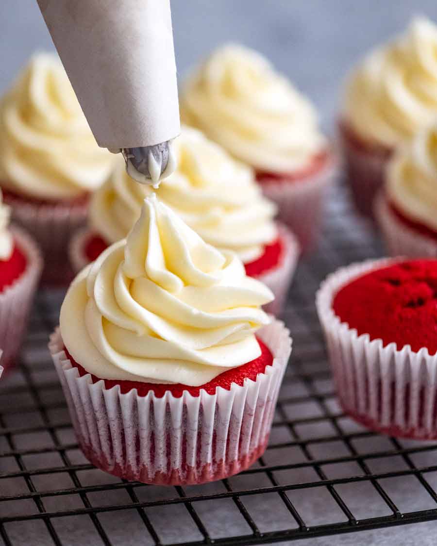 Untar glaseado de queso crema sobre los cupcakes Red Velvet