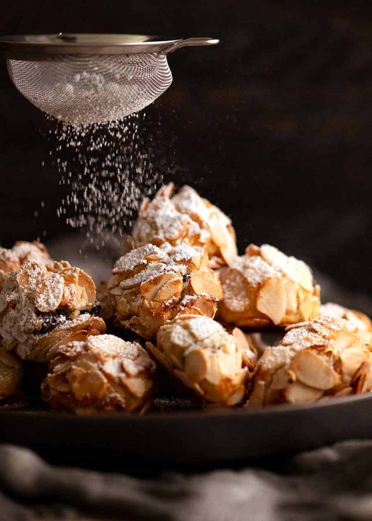Espolvorear azúcar glas sobre galletas de almendras italianas