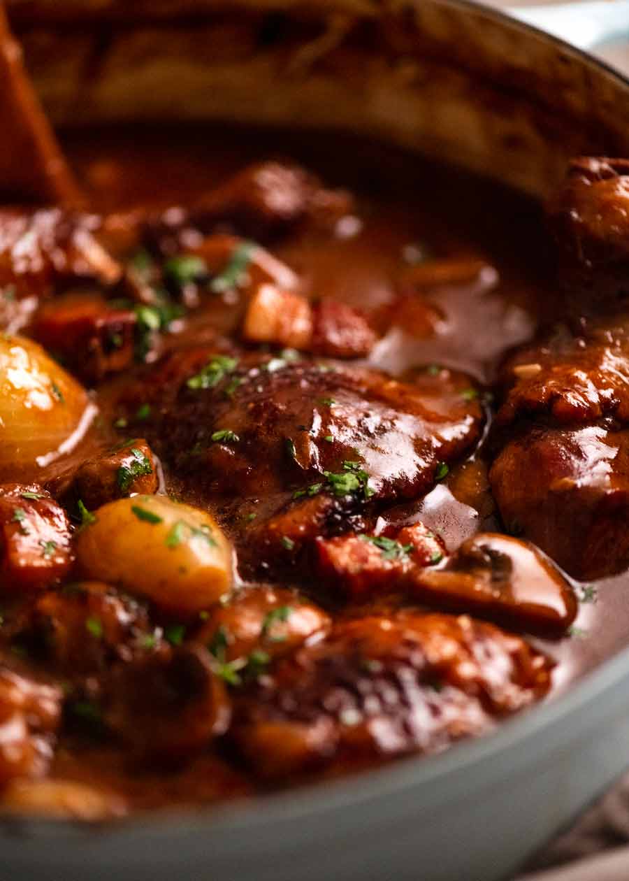 Cerrar foto de Coq au Vin - estofado de pollo francés en una olla, recién salido de la estufa
