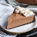 Una rebanada de tarta de queso Nutella con crema batida.