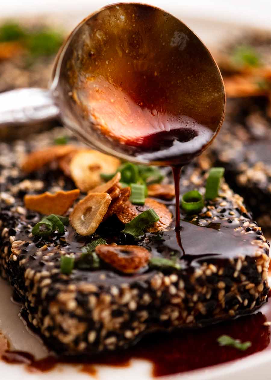 Rociar salsa teriyaki sobre filetes de tofu con costra de sésamo
