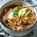 Sopa de enchilada de pollo en un tazón con una cuchara
