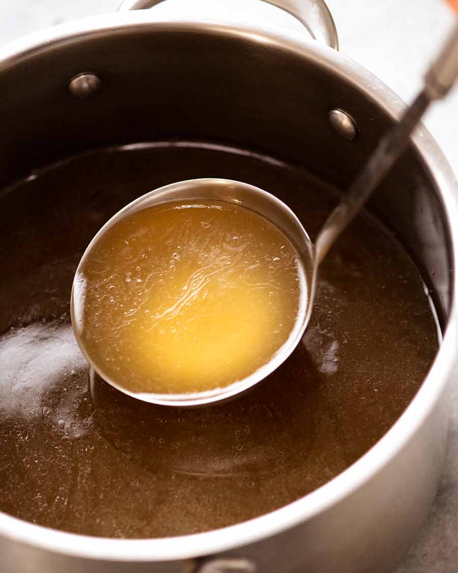 Cucharón recogiendo caldo de pollo casero