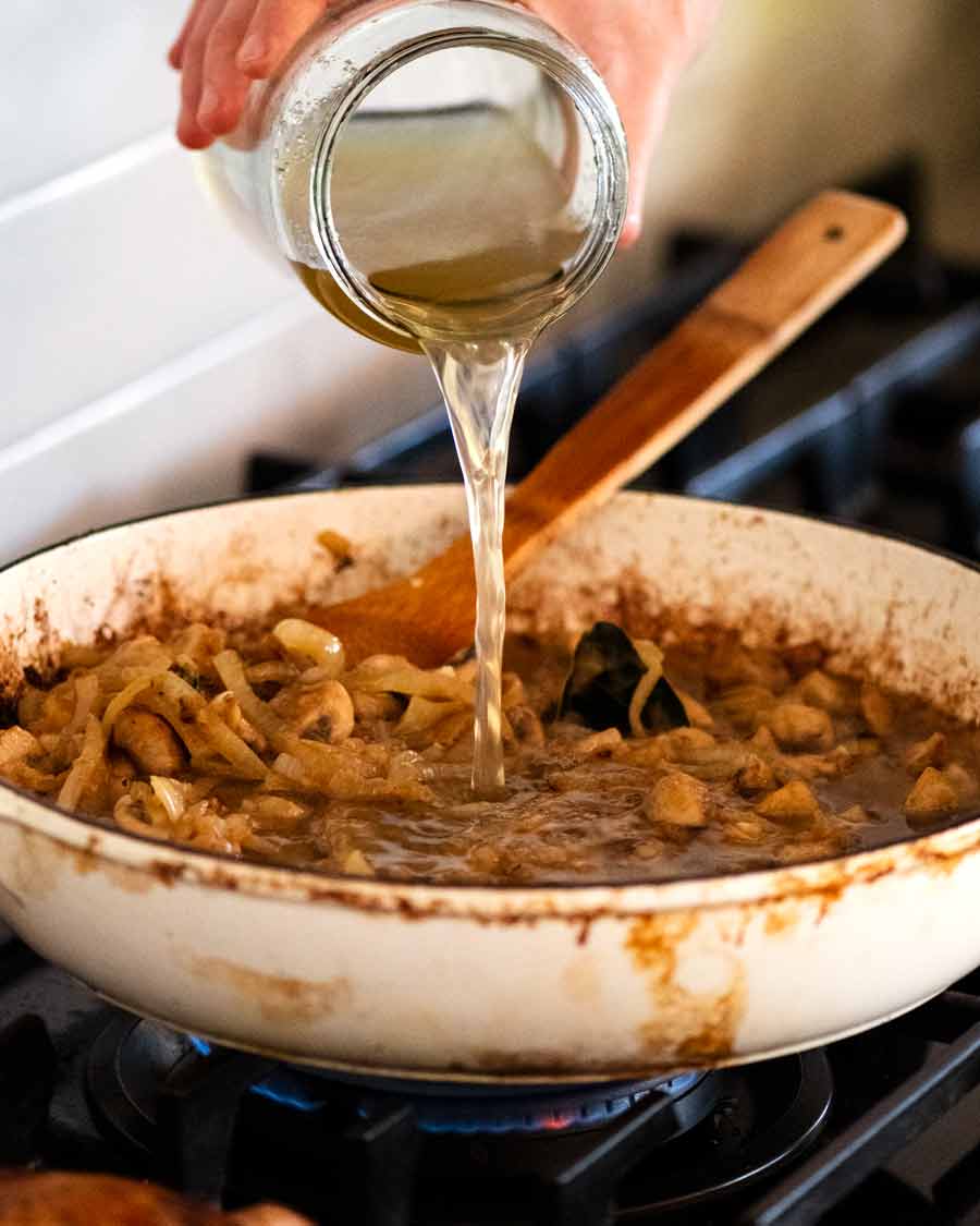 Verter caldo de pollo casero en una olla para Chicken Fricasse