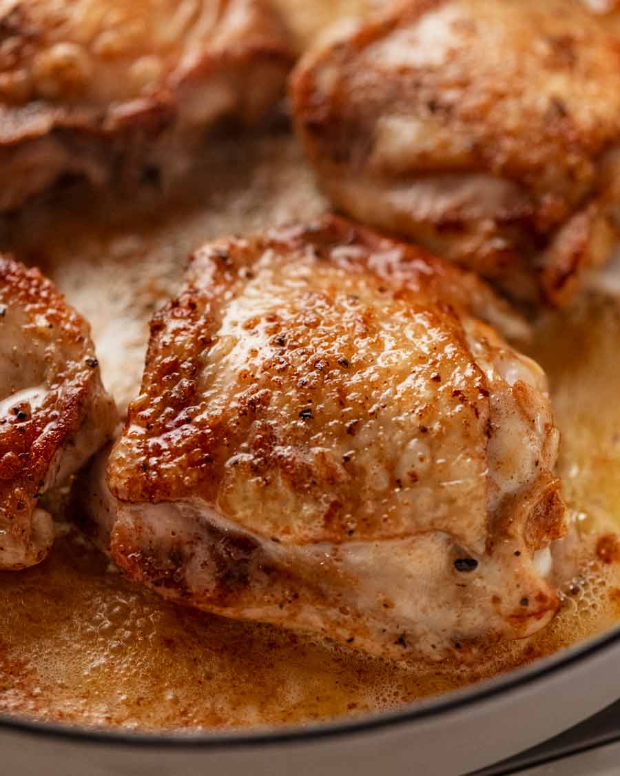 Cerca de las chuletas de muslo de pollo braseadas de color marrón dorado