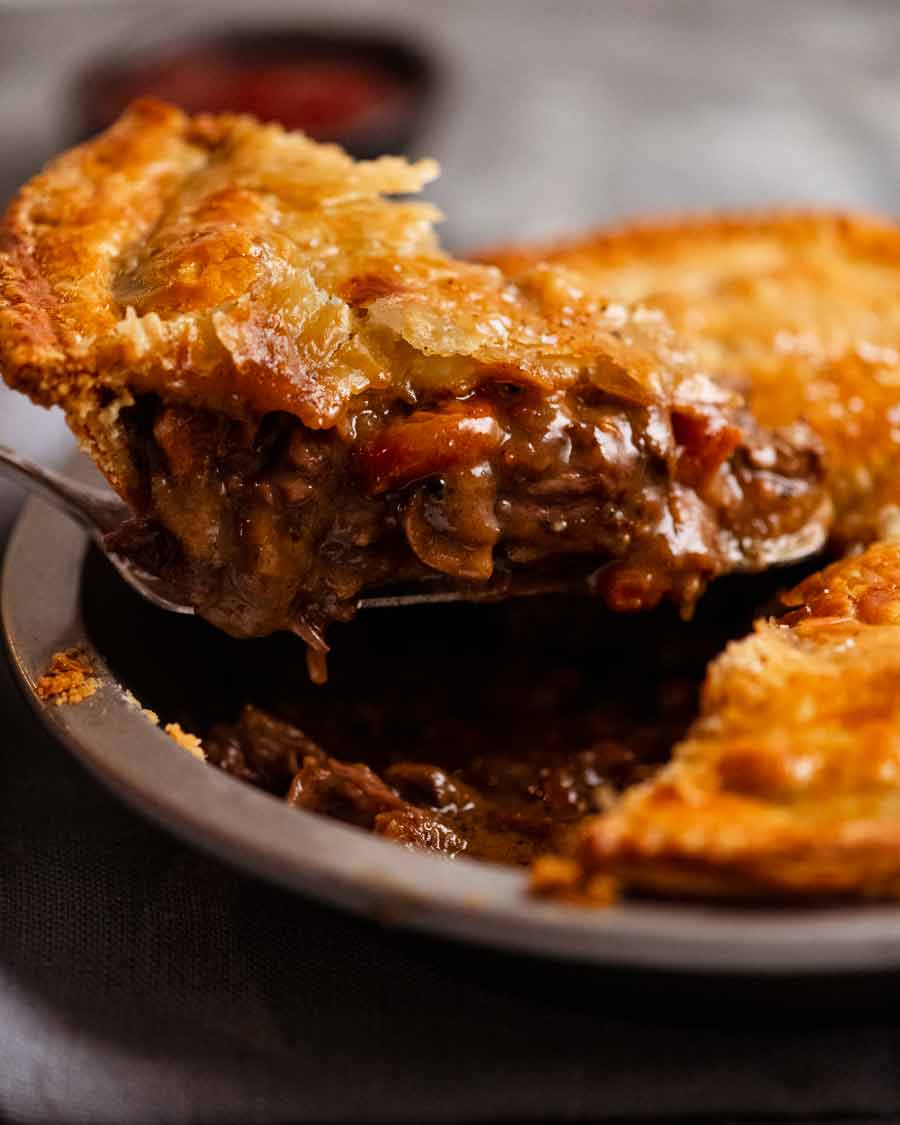 Sacar una rebanada de Family Meat Pie recién cocinado