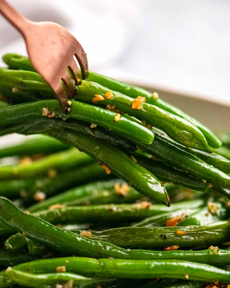 Tenedor recogiendo judías verdes salteadas con ajo