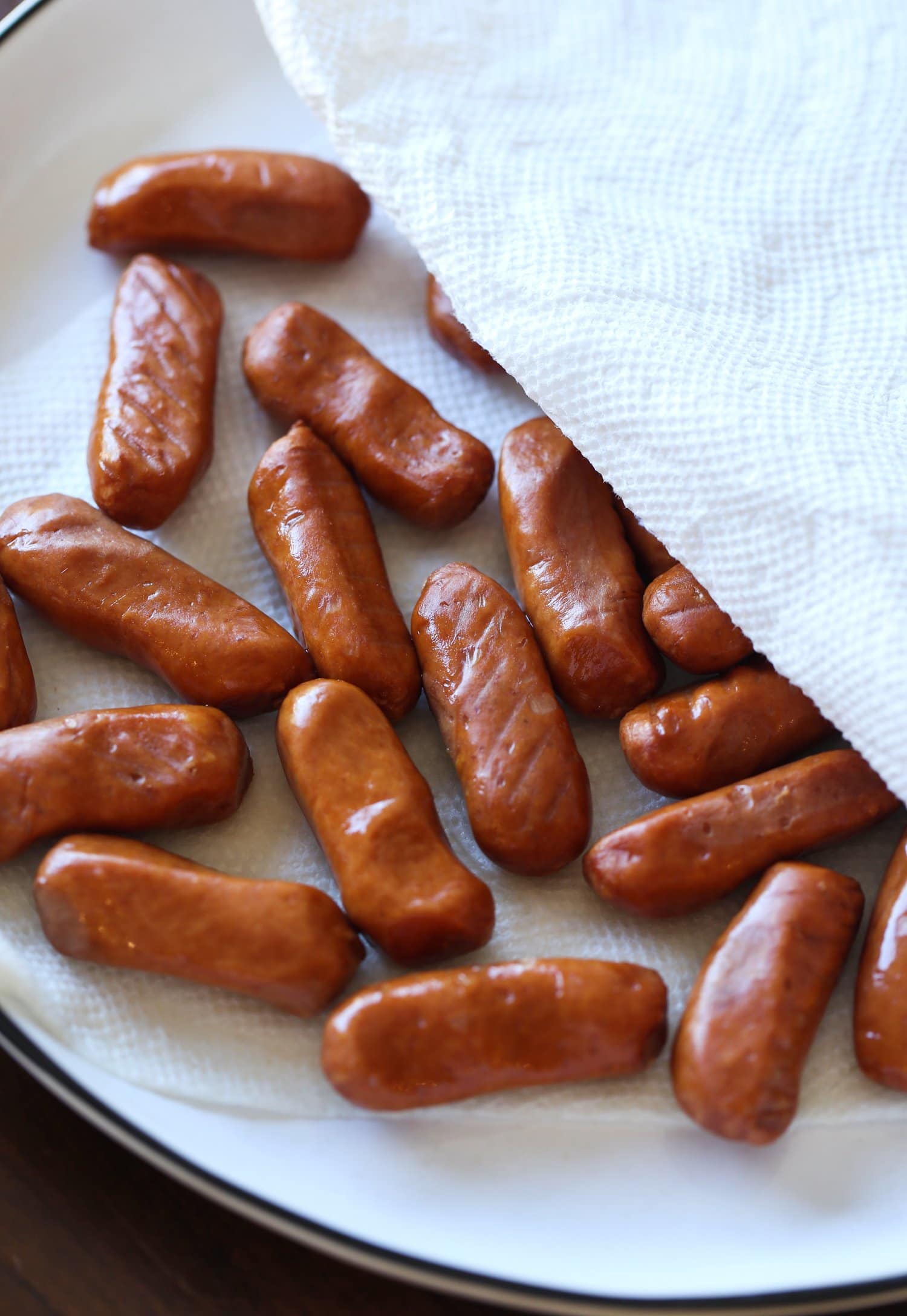 Las salchichas de cóctel se secaron con palmaditas en un plato.