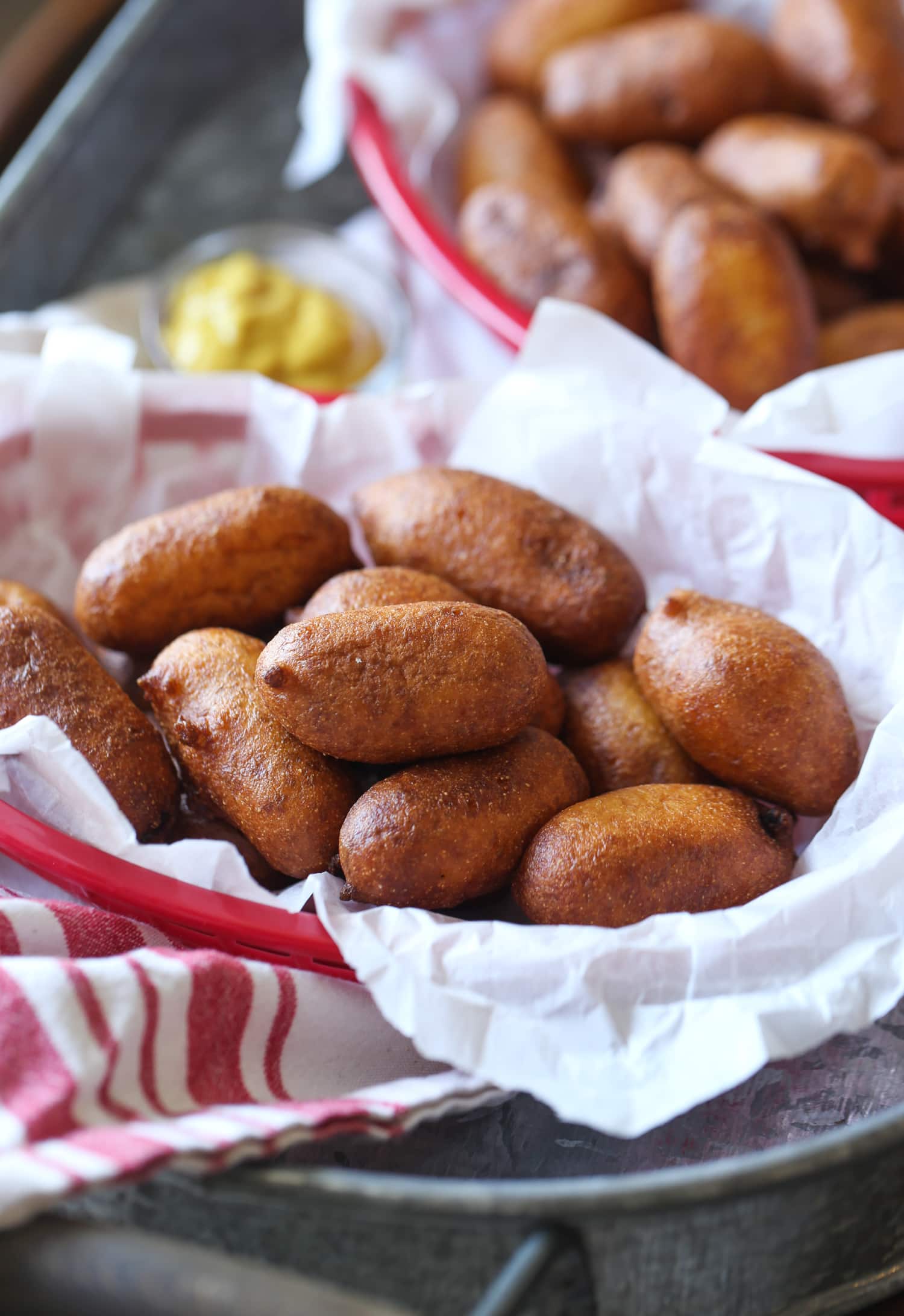 Una canasta de mini hot dogs fritos en masa de harina de maíz.