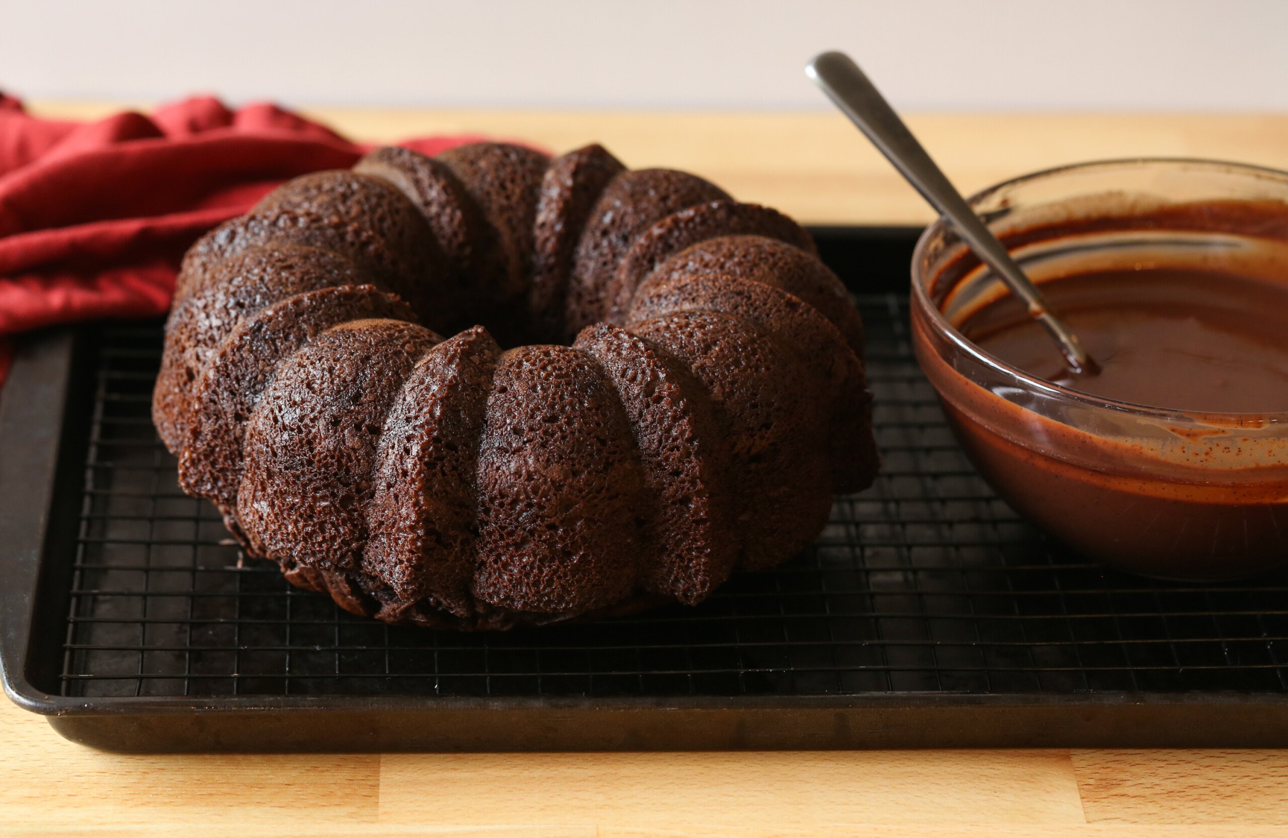 bizcocho de chocolate en una rejilla para enfriar con ganache en un bol