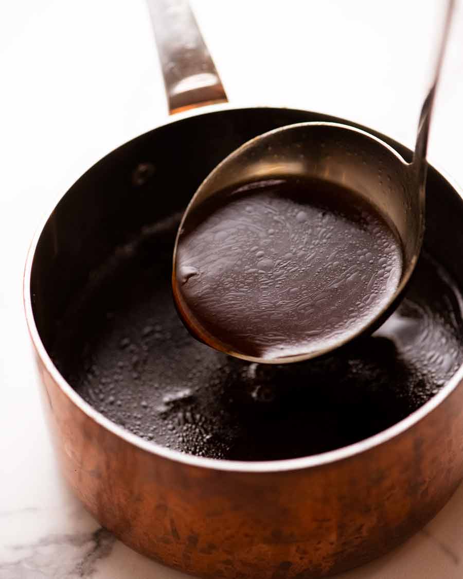 Salsa de Jus para paleta de cordero asada a fuego lento 12 horas en una fuente con ptoatoes asado con limón