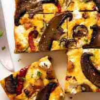 Fotografía aérea de frittata al horno con verduras asadas cortadas en rodajas, recién salida del horno