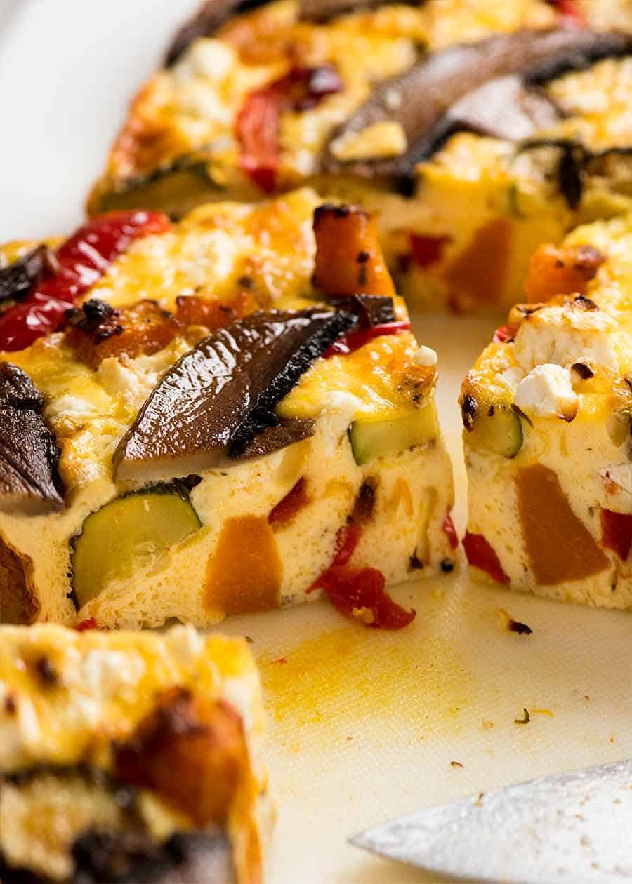 Cerca de una rebanada de frittata al horno con verduras asadas