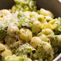 Cerca de pasta de brócoli con queso en un recipiente, listo para ser comido