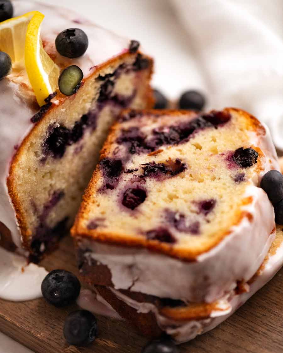 Cerca de una rebanada de Blueberry Lemon Loaf, receta fácil de tarta de arándanos