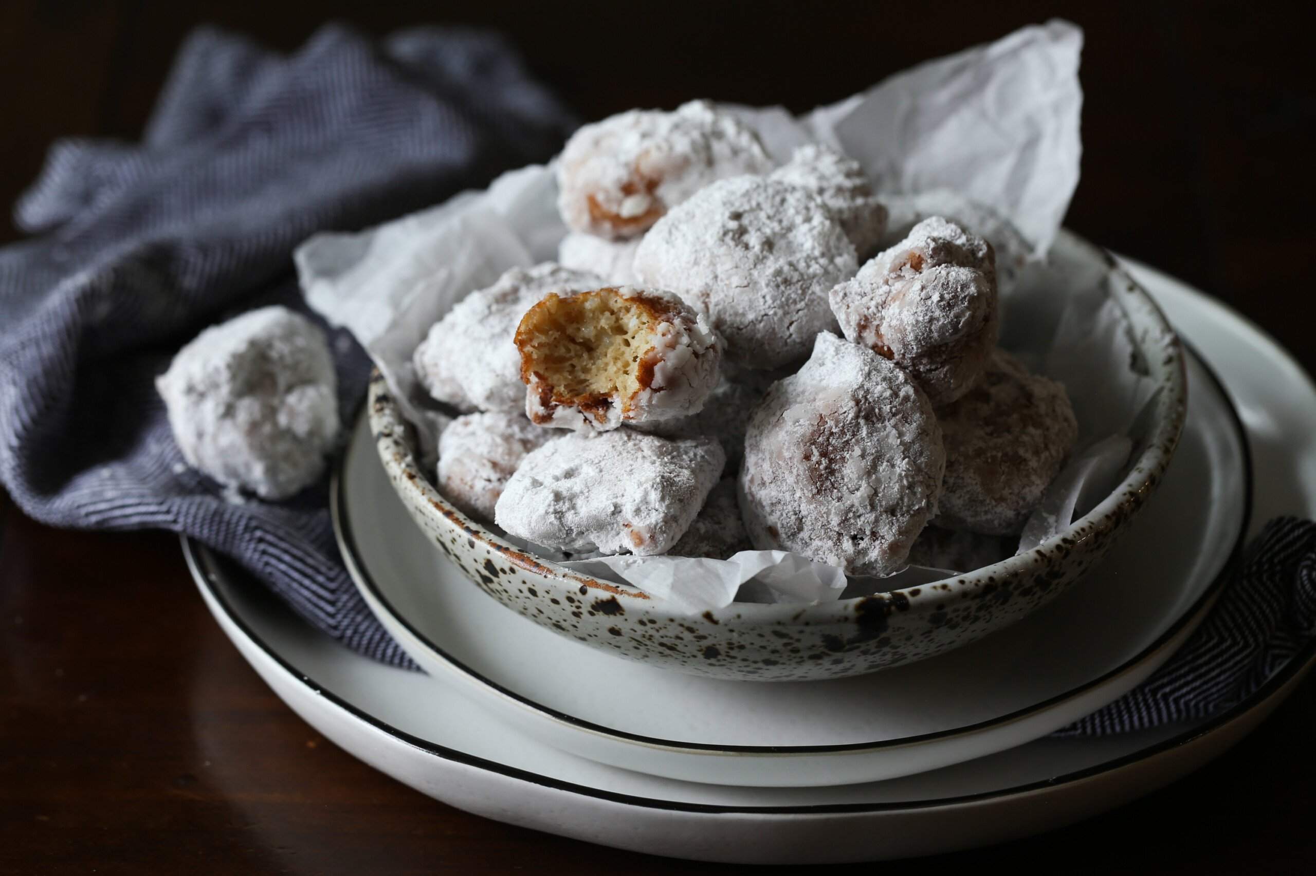 Recipiente lleno de buñuelos de arroz recubiertos de azúcar en polvo