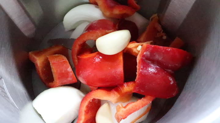 Ponemos en el vaso el pimiento y la cebolla y la picamos