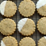 Chai Shortbread en una rejilla para enfriar medio sumergido en chocolate blanco