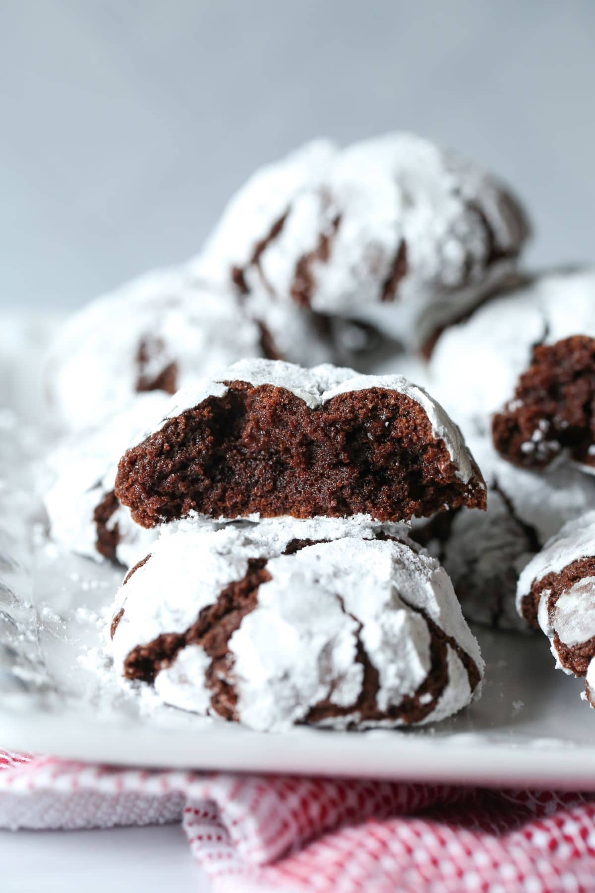 Galletas de chocolate arrugadas en un plato blanco, con una de las galletas rota por la mitad y los lados rotos hacia la cámara.