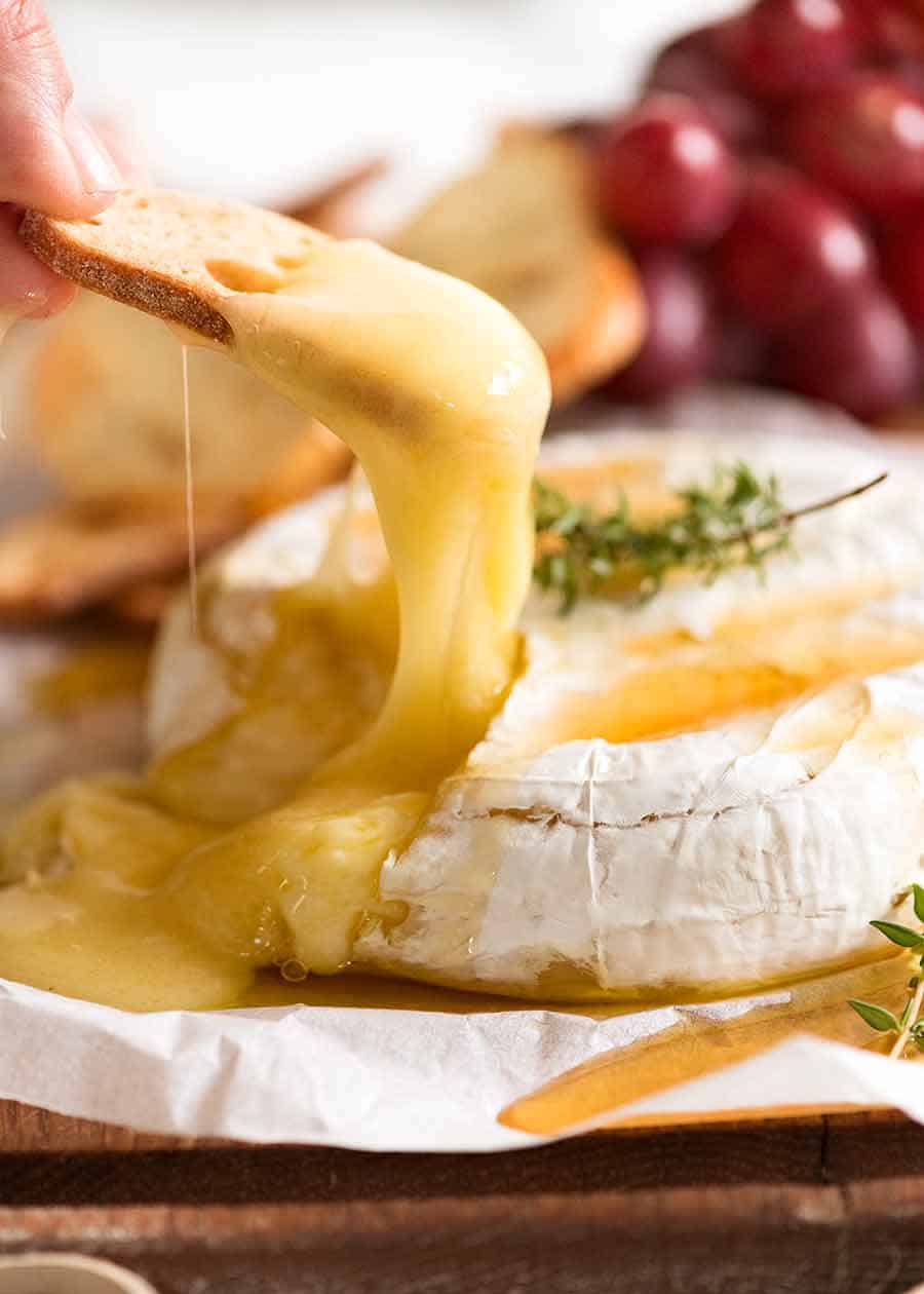 Cerca de crujiente pan tostado recogiendo Brie horneado