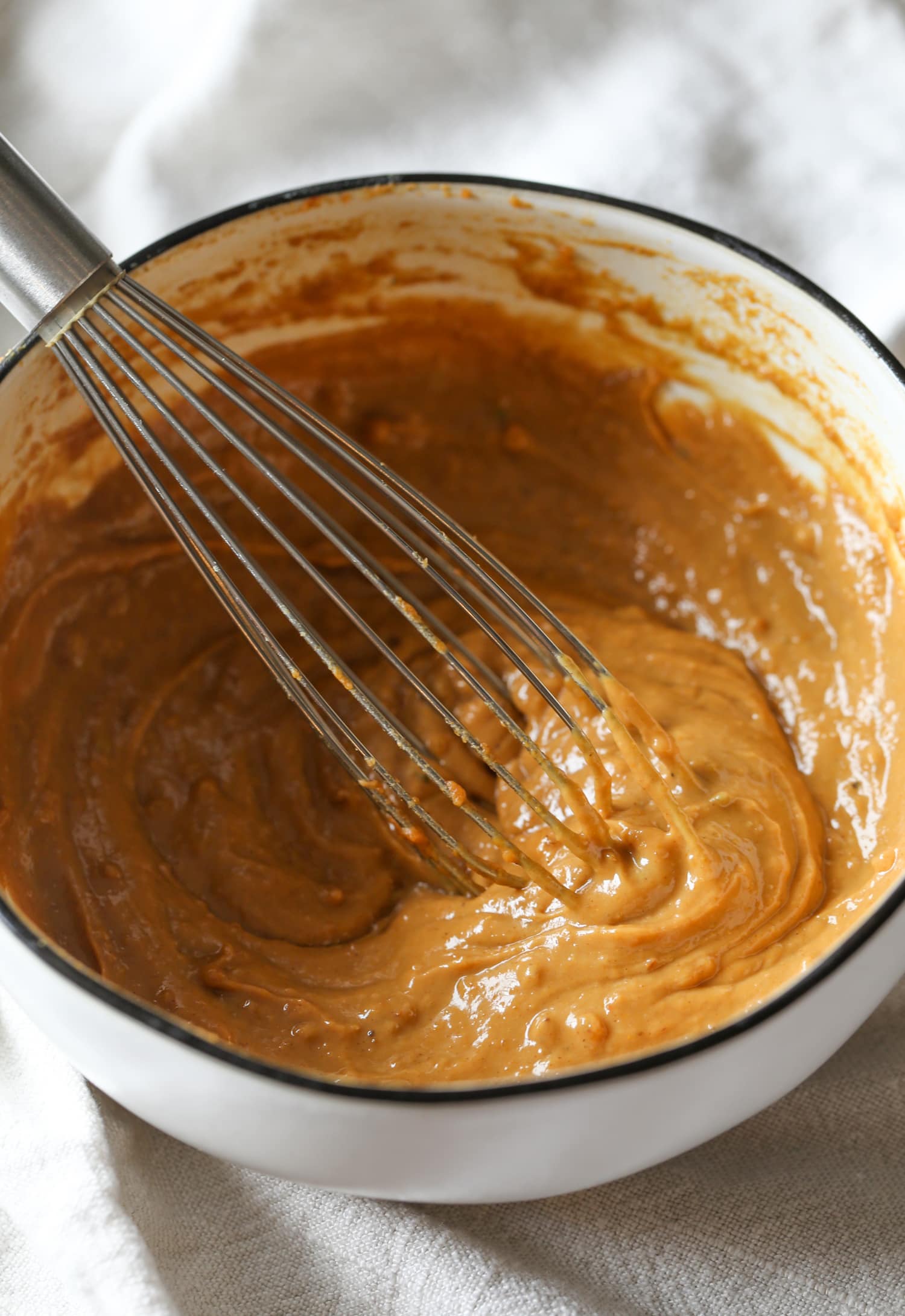 La mantequilla de maní, el jugo de lima, la salsa de soja, el chile y las especias se mezclan para obtener la salsa de maní casera.
