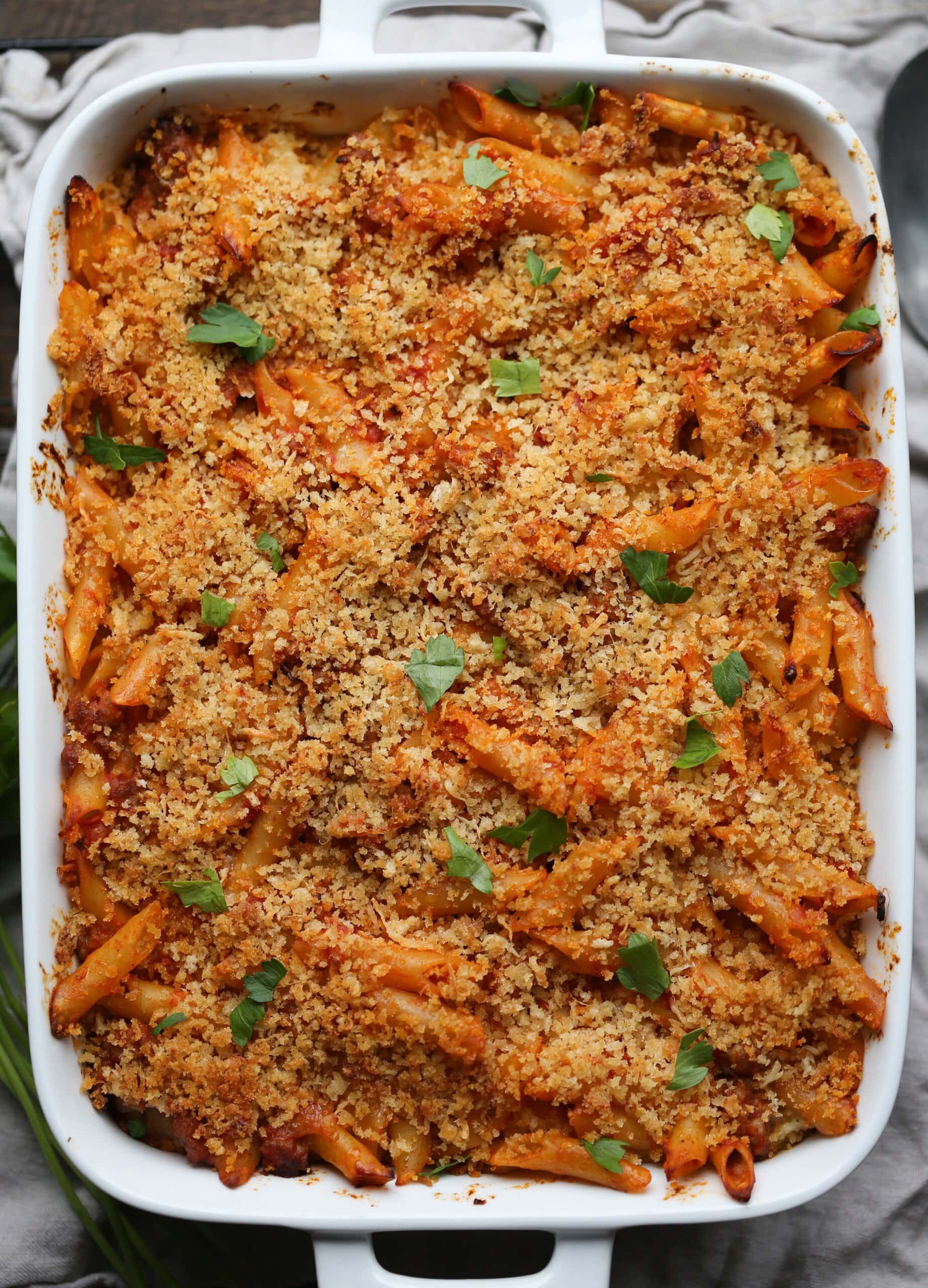 Mostaccioli al horno cubierto con queso parmesano, pan rallado y hierbas frescas.