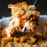 Una cucharada de mostaccioli horneado con queso se sirve en una cacerola.