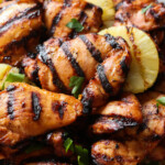 Muslos de pollo huli huli a la parrilla hawaiano con piña en un plato.