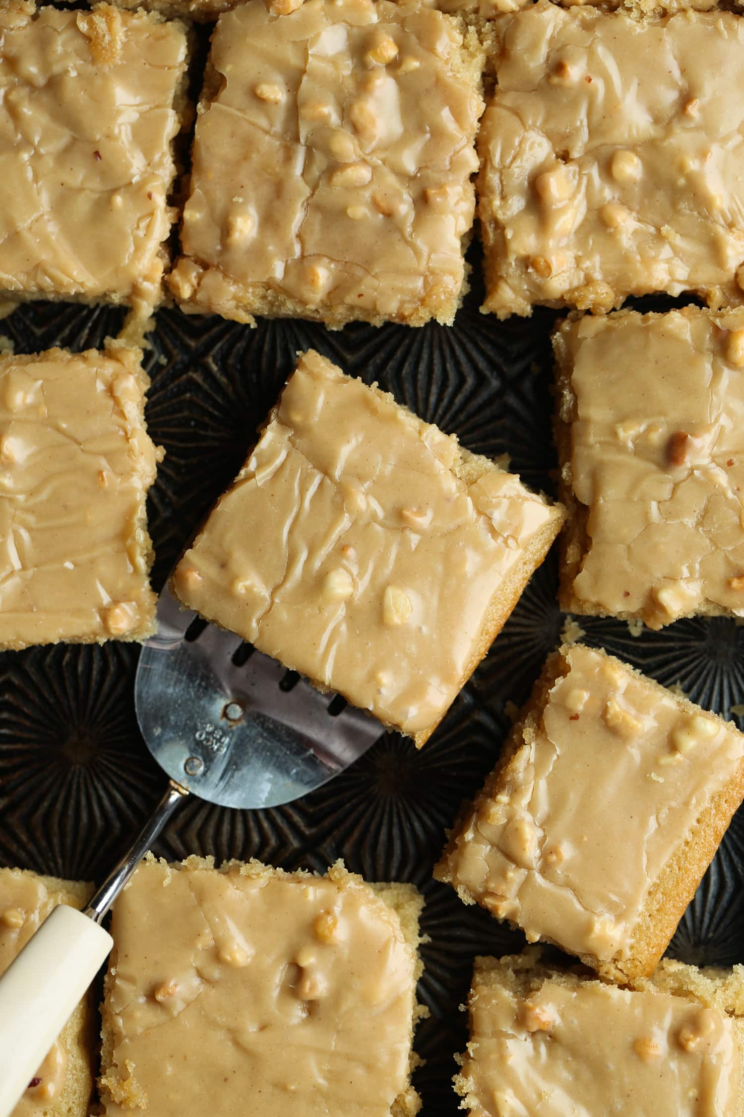 Rebanadas cuadradas de pastel de mantequilla de maní con glaseado de mantequilla de maní.