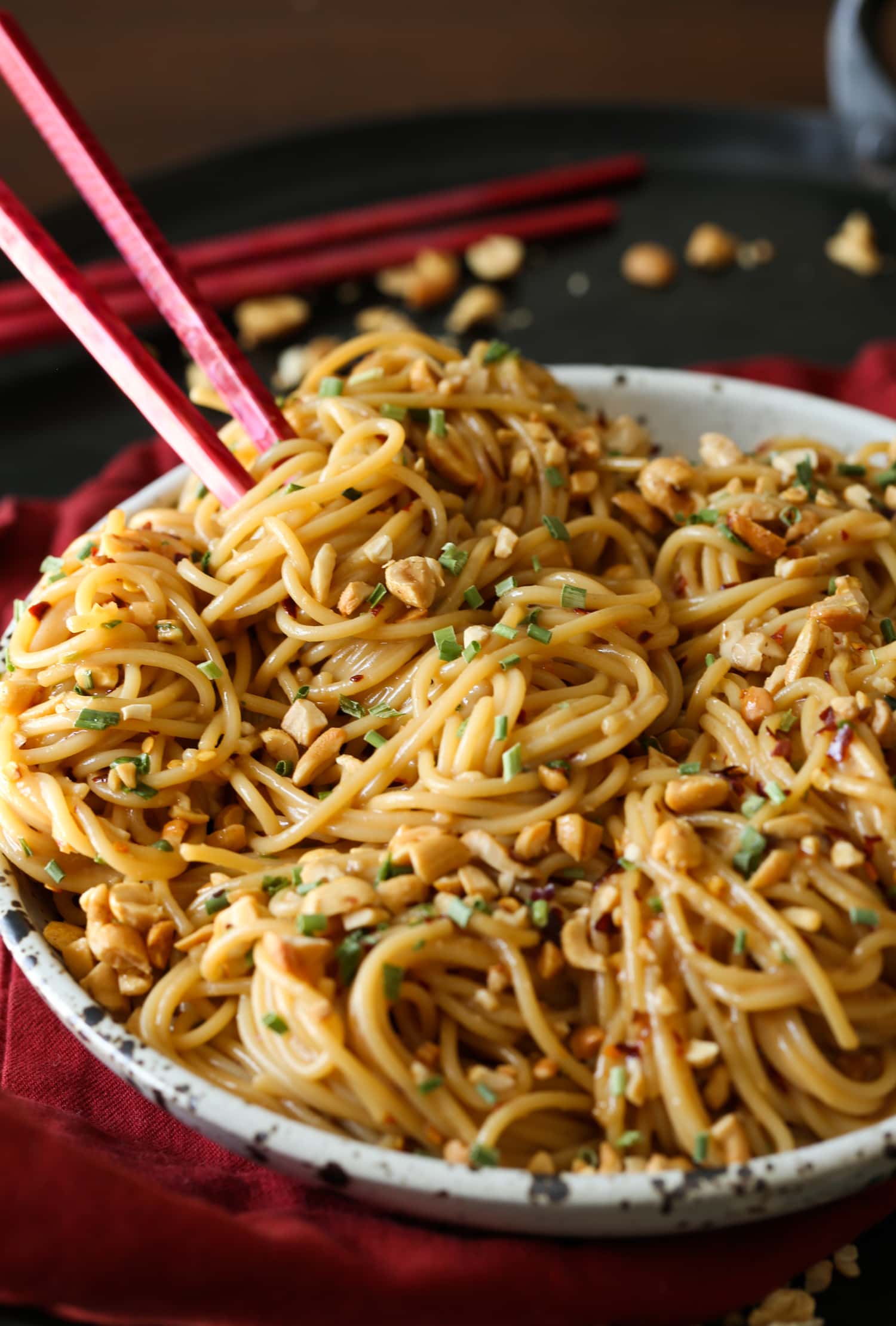 Un plato de fideos picantes de sésamo con palillos.