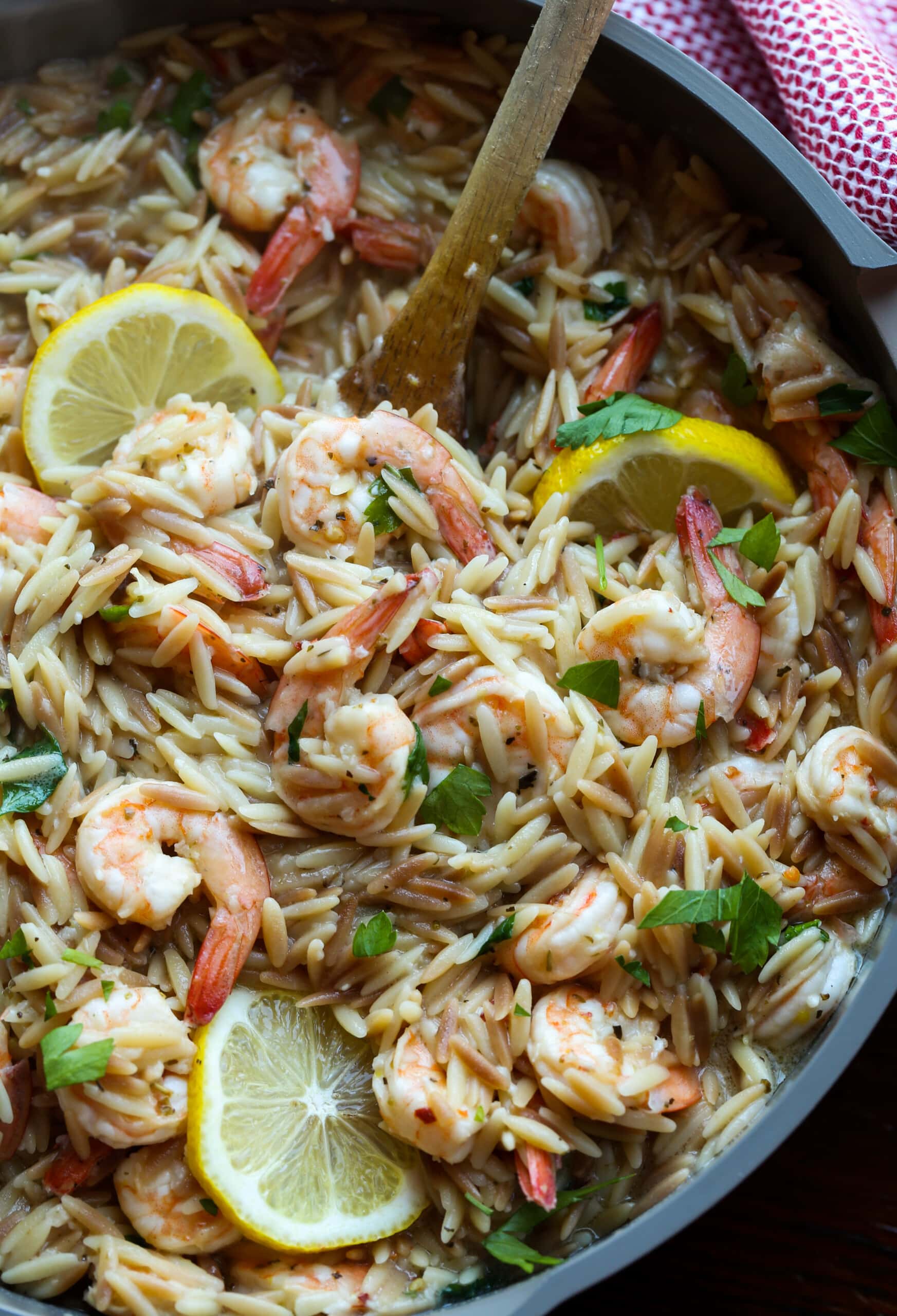 Camarones orzo en una sartén con limones.