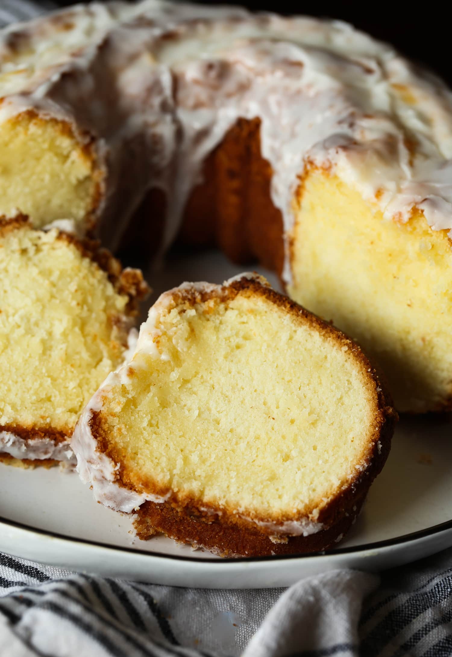 Primer plano de rebanadas de pastel junto a un pastel bundt 7UP en un plato.
