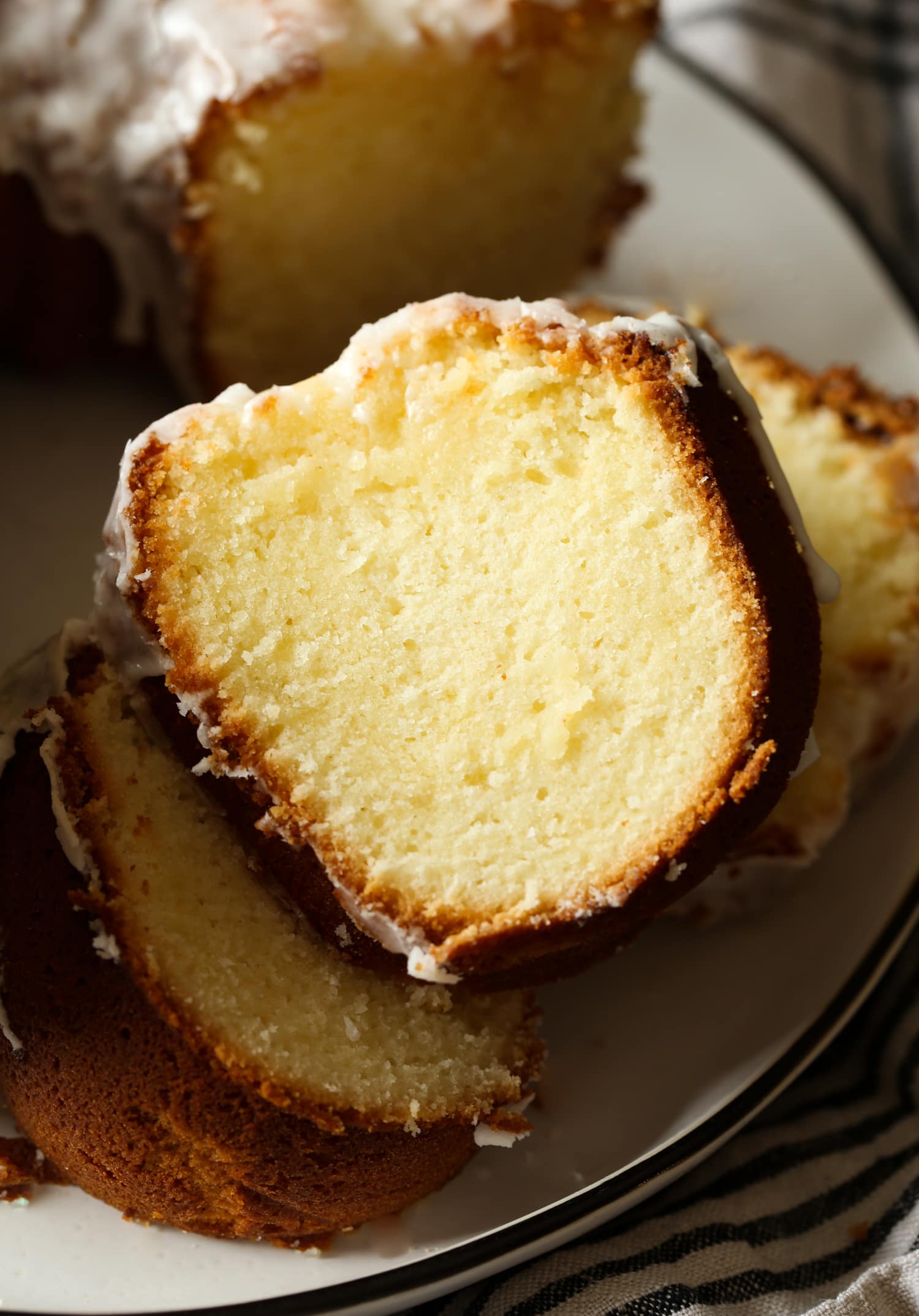 Primer plano de rebanadas de pastel junto a un pastel bundt 7UP en un plato.