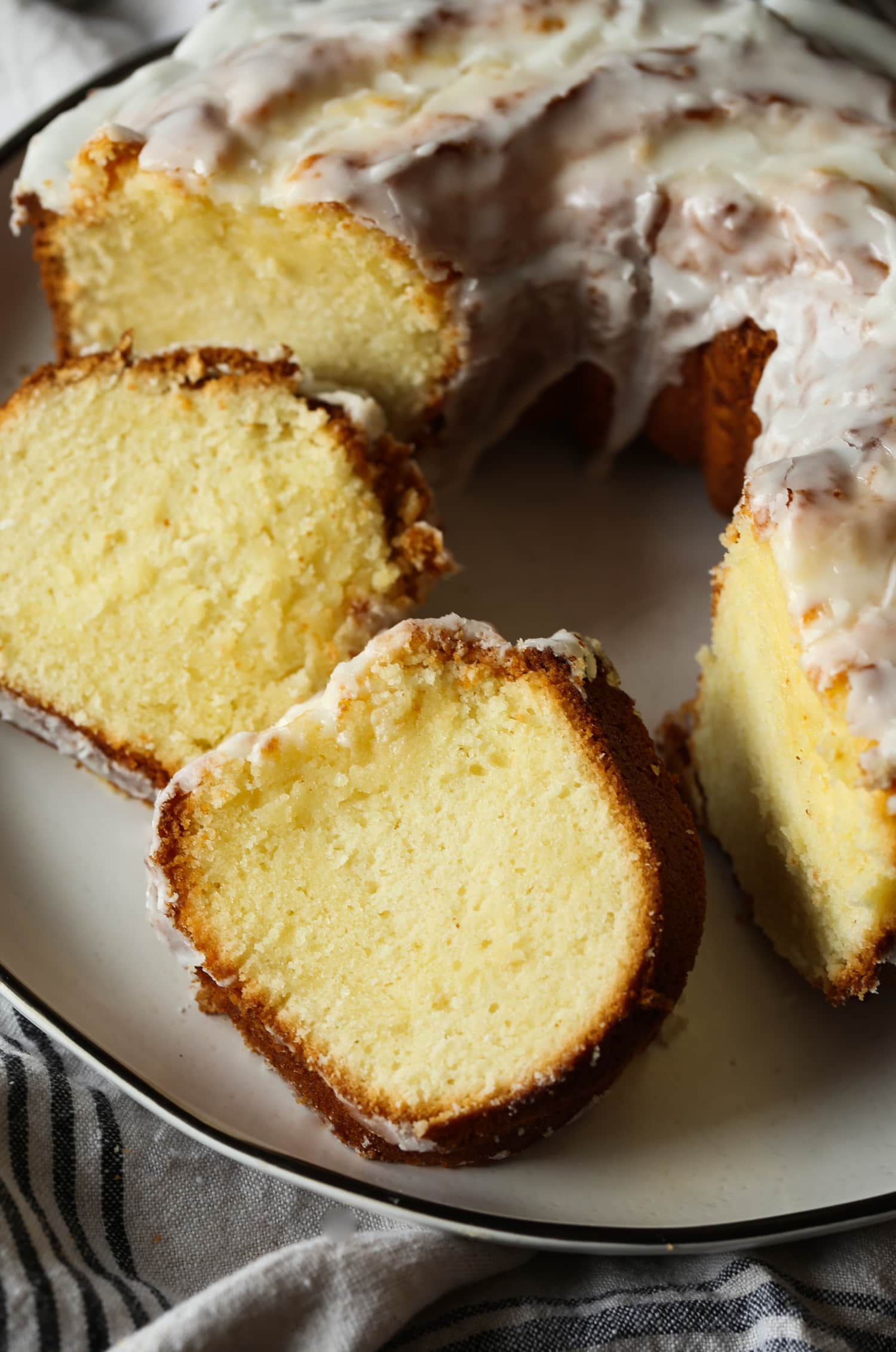 Primer plano de rebanadas de pastel junto a un pastel bundt 7UP en un plato.