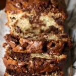 Una hogaza de pan de plátano marmoleado con chocolate cortado en rodajas para revelar el interior marmolado.