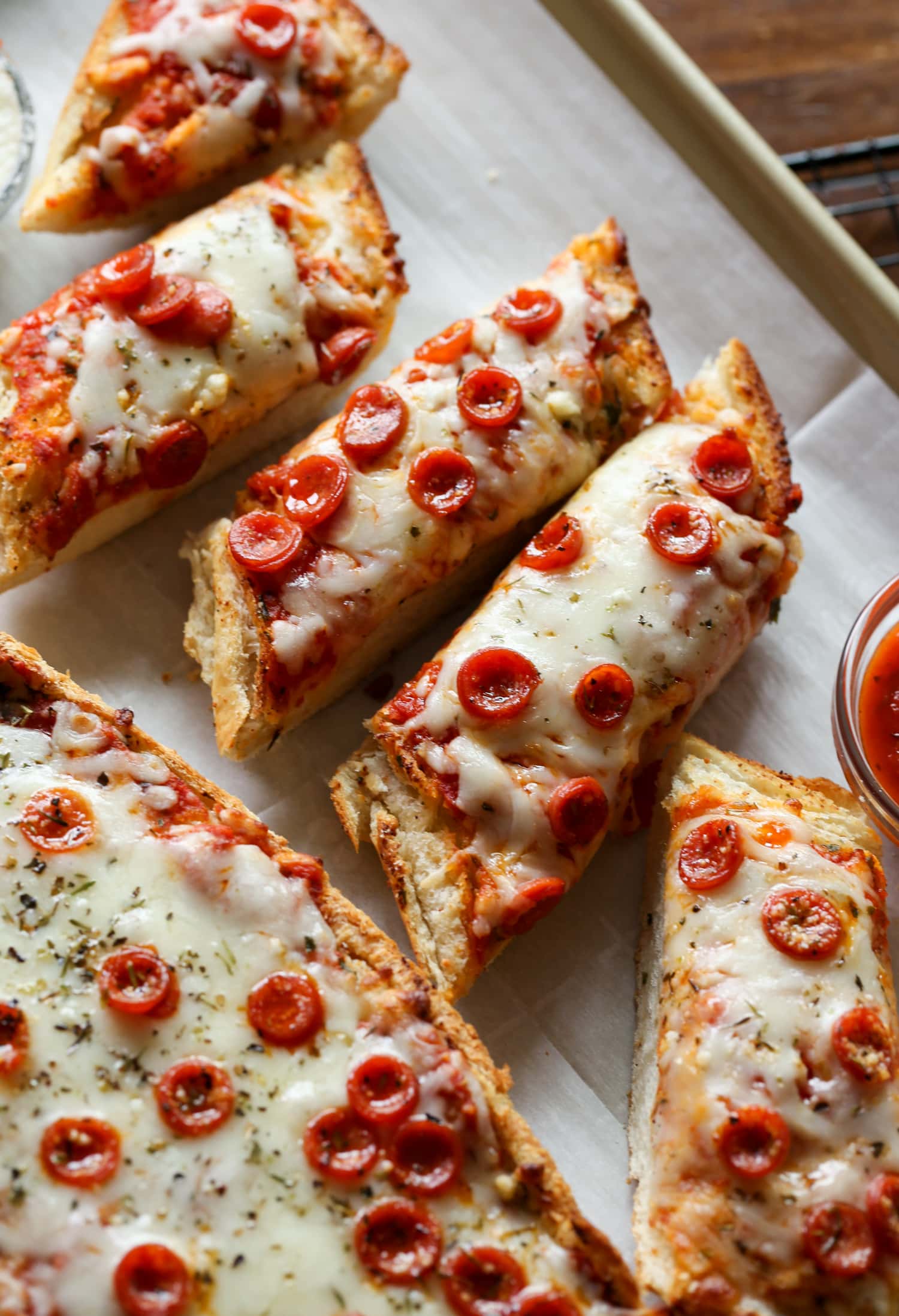 Pizza de pan francés cortada en rebanadas individuales en un plato.