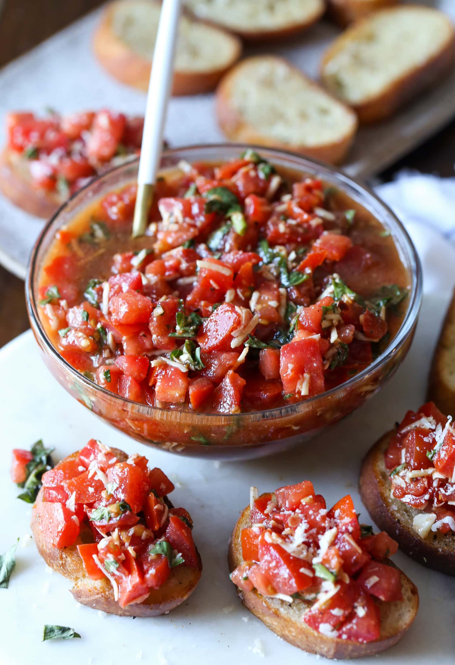 Un plato de bruschetta rodeado de tostadas de bruschetta.