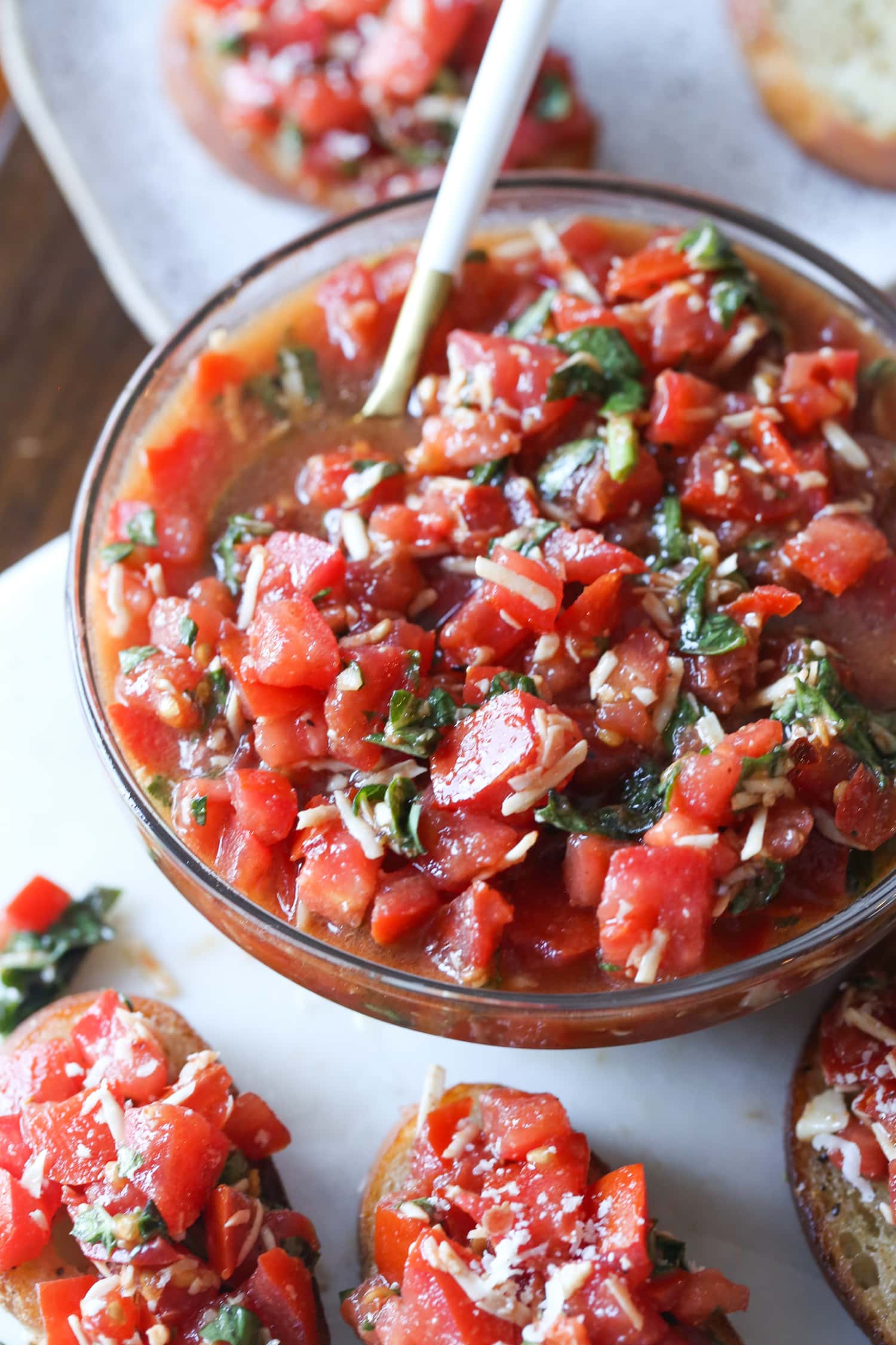 Un plato de bruschetta rodeado de tostadas de bruschetta.