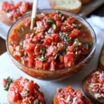 Un plato de bruschetta rodeado de tostadas de bruschetta.