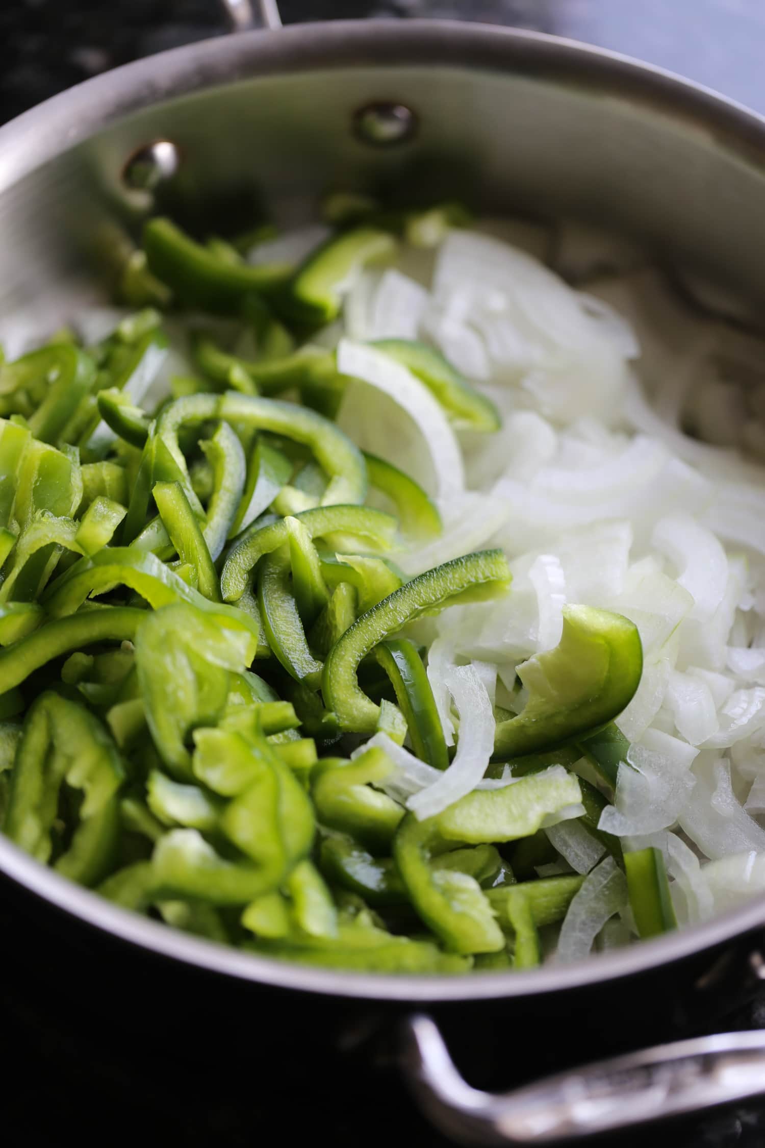 Pimientos verdes y cebollas en una olla grande.
